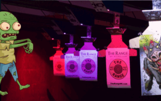 Colorful illuminated bottles hanging in a row with brand logos.