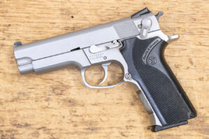 Close-up of a silver semi-automatic handgun on a wooden surface.